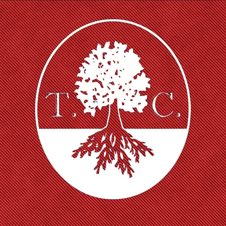 A stylized tree with roots, enclosed in an oval, on a red background in Uvalde County, Texas