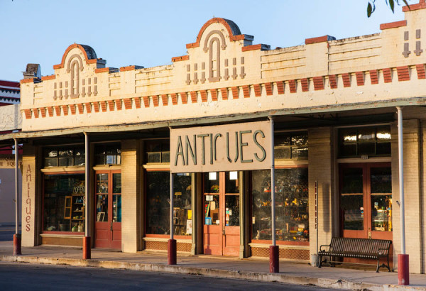 A vintage storefront with the word 'ANTIQUES' prominently displayed above the entrance in Uvalde County, Texas