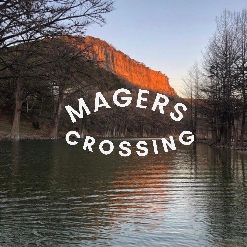 A serene lake with a reflection of a rocky cliff bathed in golden light at sunset in Uvalde County, Texas