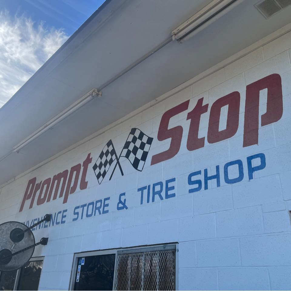 Prompt Stop, a tire shop with a large sign featuring checkered flags, is located in Uvalde County, Texas in Uvalde County, Texas