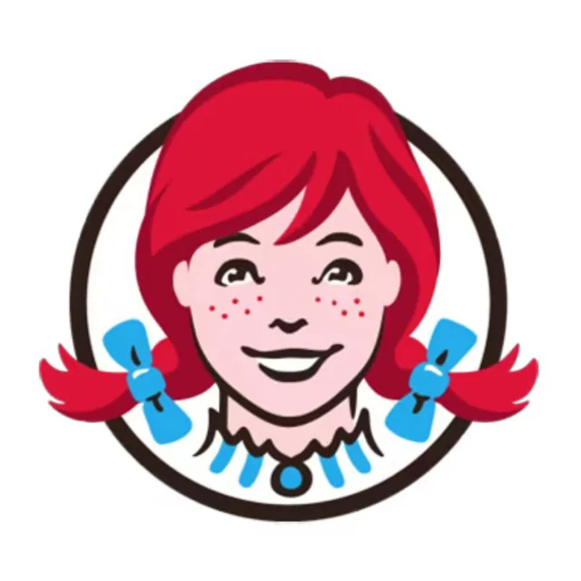 A cheerful cartoon girl with red pigtails tied with blue bows and freckles on her face in Uvalde County, Texas
